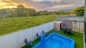 A rooftop pool with a view of a grassy field and distant mountains. - Modern Uvita Beachhouse by Whale's Tale  (Bahía Ballena)