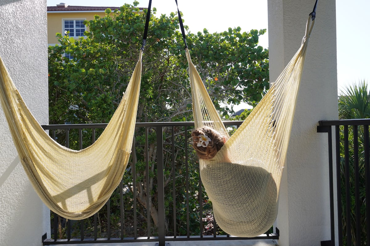 A hammock suspended between two columns on an outdoor balcony.