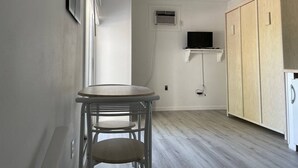 A small kitchen with a round table, a ceiling fan, and wooden cabinets.