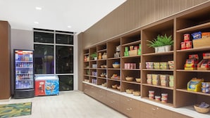 A modern interior with a vending machine, snack shelves, and a potted plant. - Anaheim | Couples Theme Park Getaway | Pool + Parks (Anaheim)