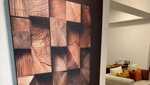 A modern living room with a geometric patterned wall art, a sofa with cushions, and a coffee table. - Luxury Apartment (Hengchun)