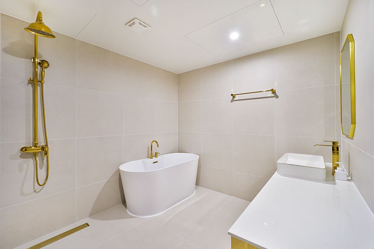 A modern bathroom with a freestanding bathtub, a showerhead, and a sink with a mirror.