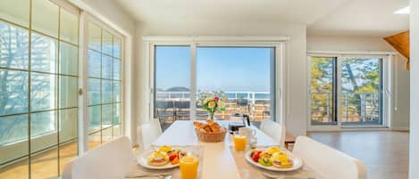 Comedor con una mesa dispuesta para el desayuno, con vistas panorámicas.