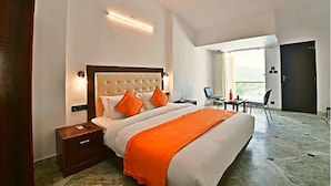 A hotel room with a large bed, a nightstand, a desk with a chair, and a balcony with a view. - Mewar Palace Resort & Spa (Udaipur)