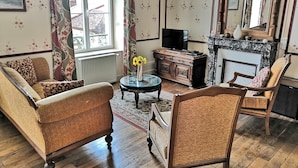 A traditional living room with a sofa, armchair, and a television.