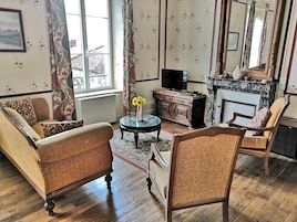 A traditional living room with a sofa, armchair, and a television.