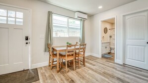 A dining area with a wooden table and chairs, a window with curtains, and a view of a backyard. - Serene Space, Explore Nearby Attractions (Fresno)
