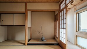 A traditional Japanese room with tatami flooring, a shoji screen, and a small vase with branches. - ANJIN Gosho Ebisugawa (Kyoto)