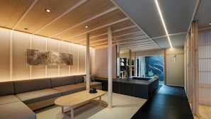 A modern living room with a sofa, a coffee table, and a kitchen area in the background. - ANJIN Gosho Ebisugawa (Kyoto)