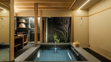A modern bathroom with a central water feature, wooden shelves, and a minimalist design.