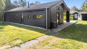 A modern house with a dark exterior, a sloped roof, and a small porch.