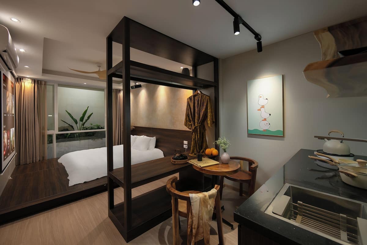 Ein modernes Hotelzimmer mit Bett, Essbereich und Küchenzeile.