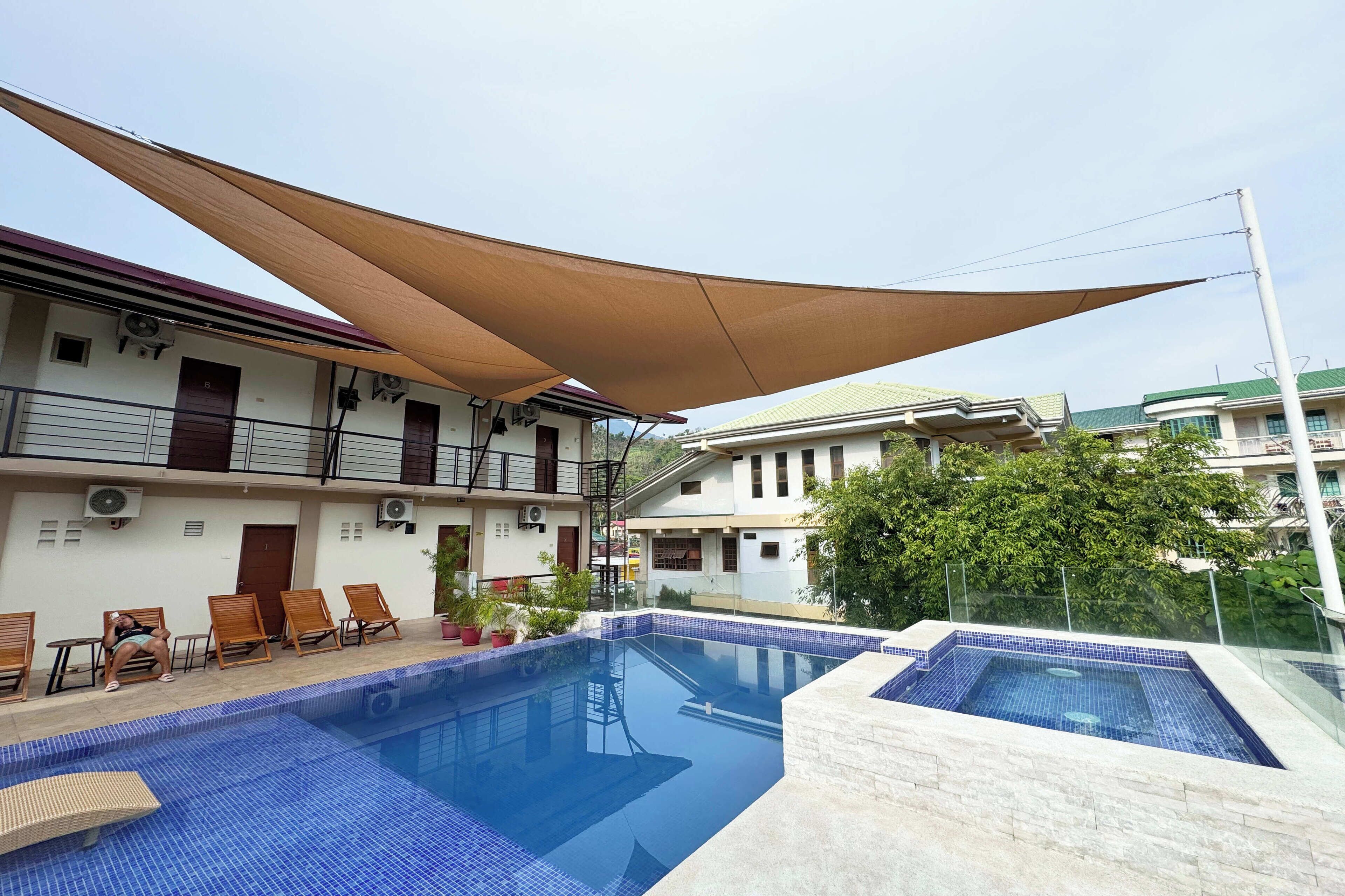 A swimming pool area with lounge chairs and a shaded canopy.