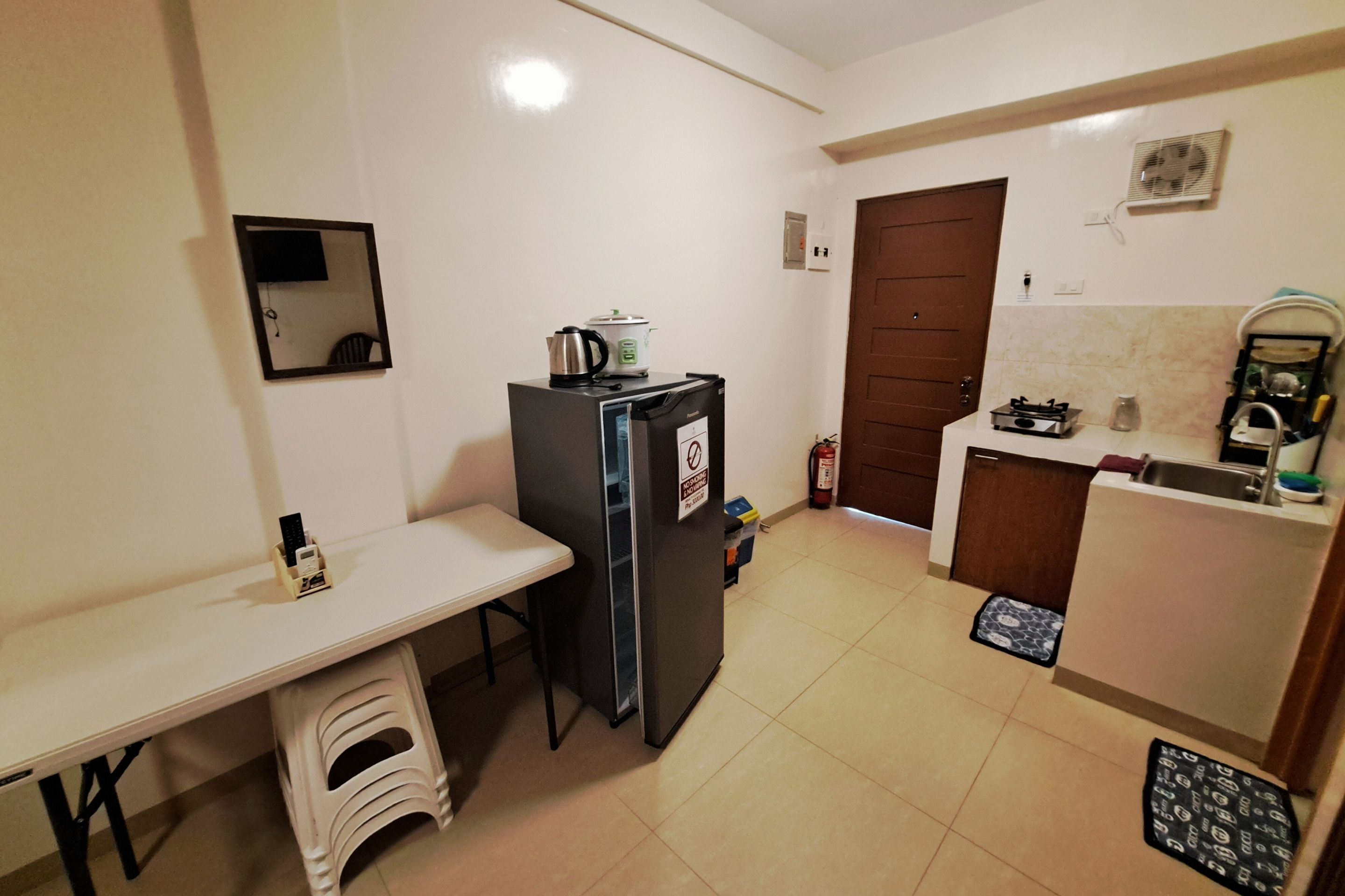 A compact kitchen with a refrigerator, a small sink, and a countertop.