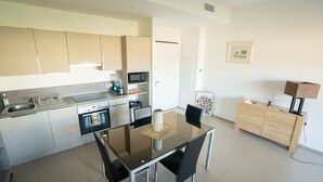 Une cuisine moderne avec une table et des chaises, un four à micro-ondes et un meuble de rangement.