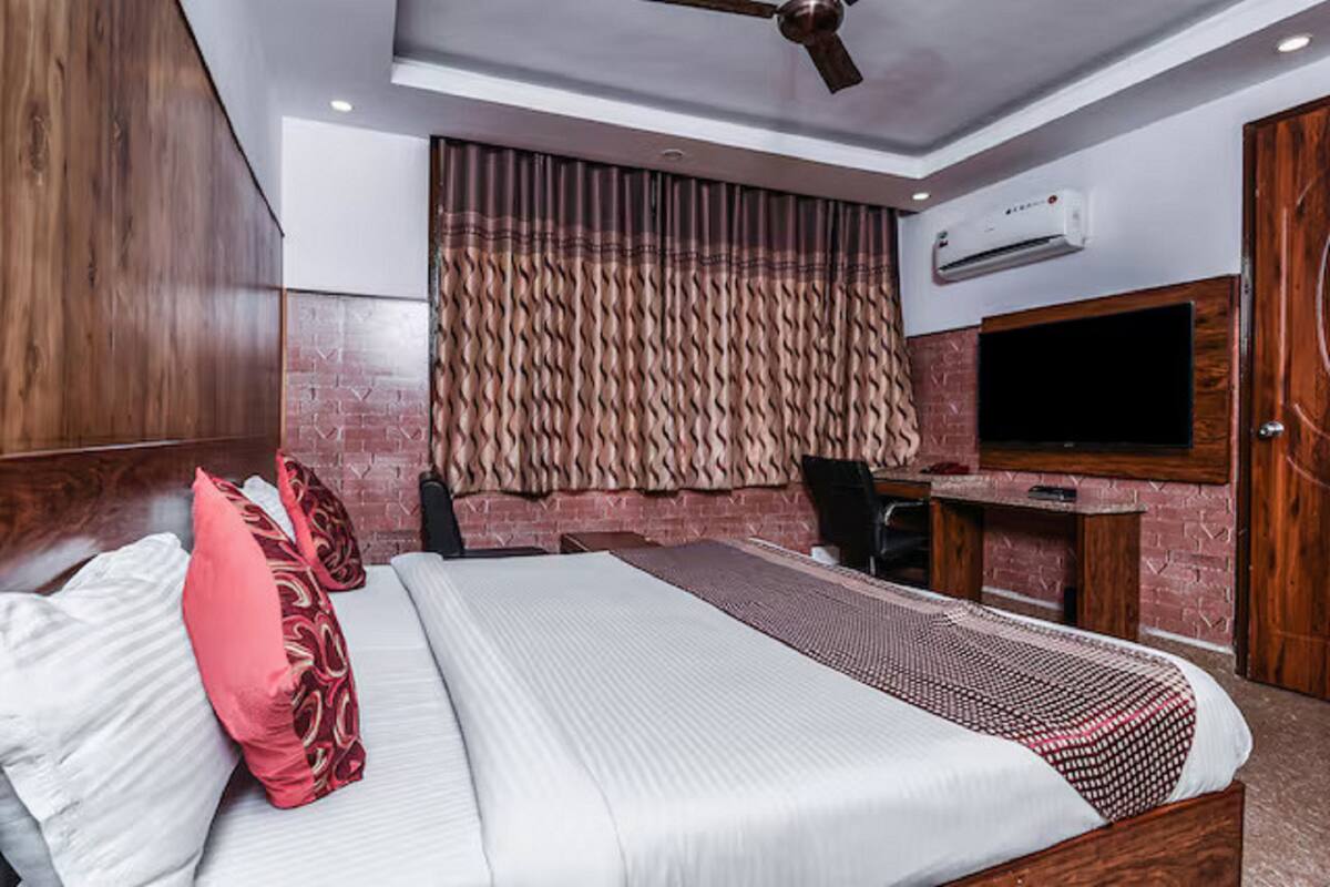 Una habitación de hotel moderna con una cama grande, un escritorio y una televisión.