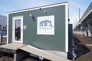 A mobile inn with a door, a ramp, and a sign indicating 'JR Mobile Inn.' - JR Mobile Inn Chitose (Chitose)