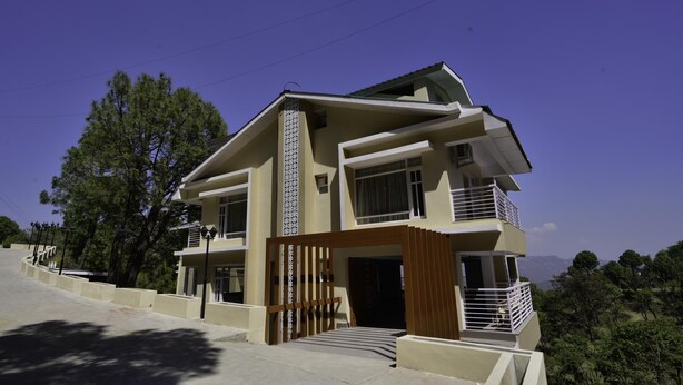 A multi-story residential building with a modern design, featuring balconies and a gated entrance. - Rajgriha Kasauli (Kasauli)