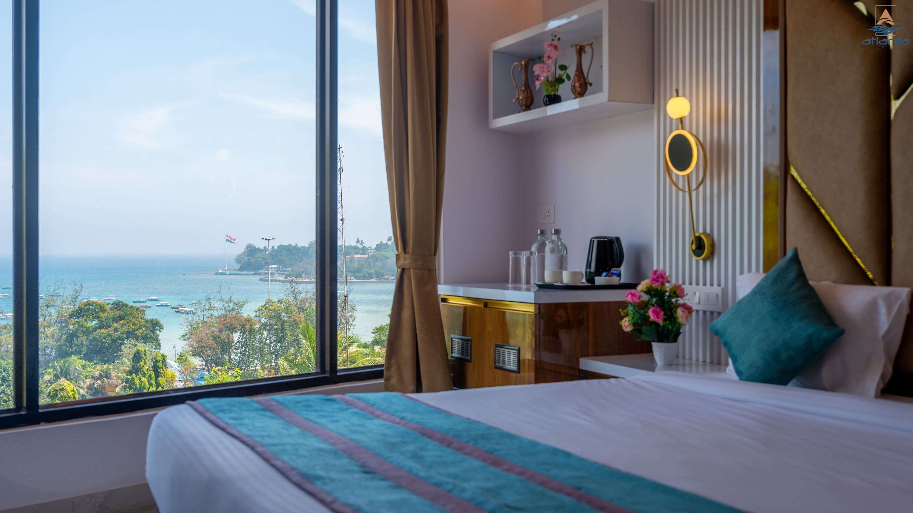 A hotel room with a large window offering a view of the sea and a flag.
