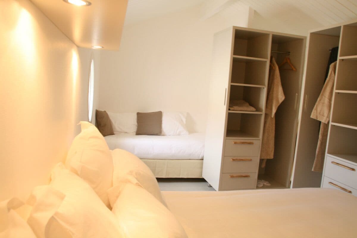 A bedroom with a bed, a wardrobe, and a closet.