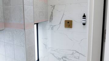 Een douche, vloerverwarming, handdoeken, zeep