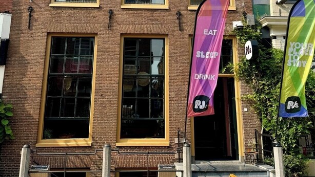 Een bakstenen gebouw met meerdere ramen en een bord waarop '9pal' staat.