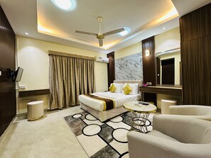 A modern hotel room with a bed, a desk, a chair, a ceiling fan, and a marble wall.