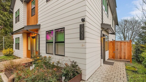 A two-story house with a wooden front door, a mailbox, and a number plaque. - The Sweetest Hideaway - 81 Walkscore! (Seattle)