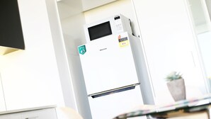 Valkoinen jääkaappi, jossa on energiatehokkuusluokitustarra, Hisense-merkki ja digitaalinen näyttö.