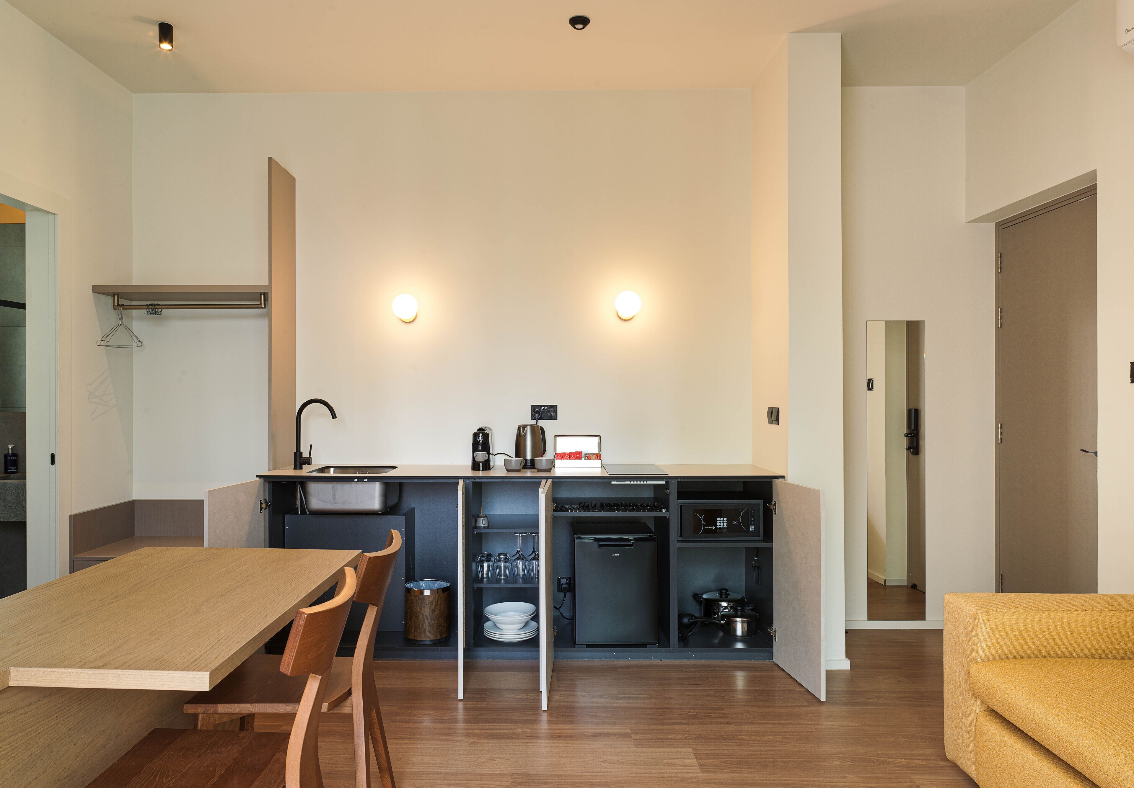 A compact kitchen with a dining table, chairs, and a built-in oven.