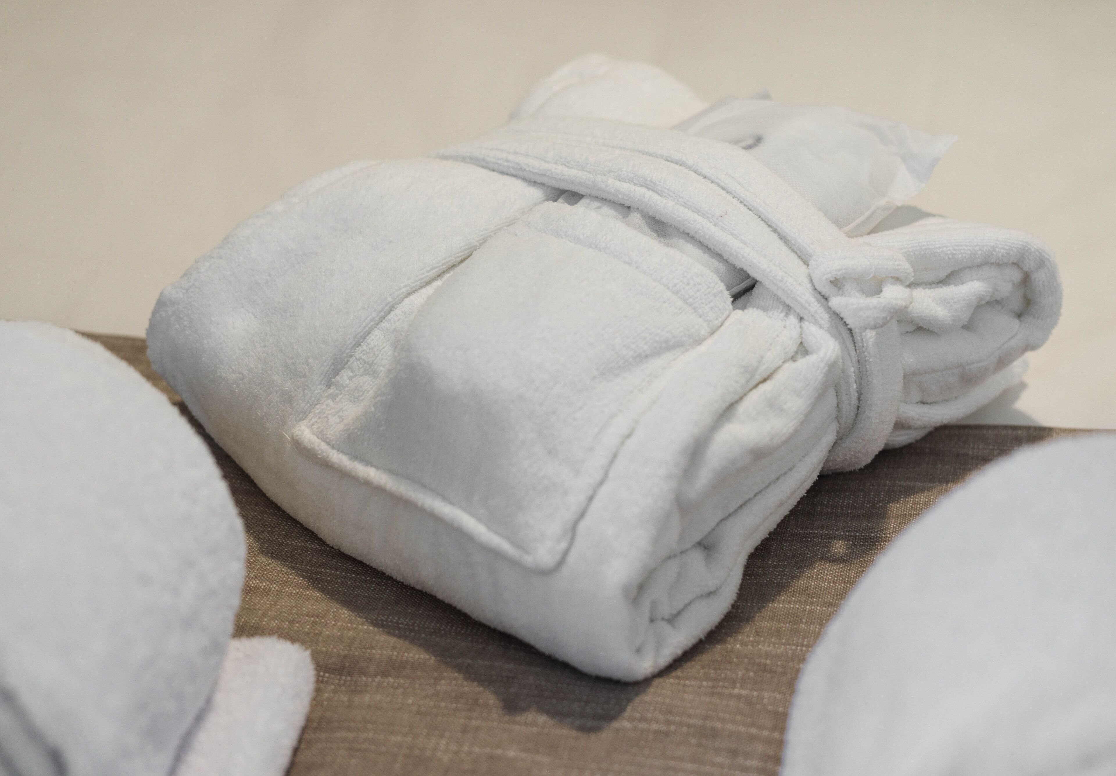 A neatly folded white towel on a wooden surface.