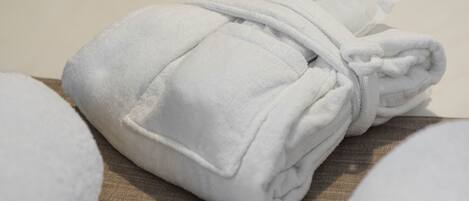 A neatly folded white towel on a wooden surface.