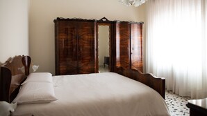 Ein Schlafzimmer mit einem großen Bett, einem Holzschrank und einer Chandelüster.