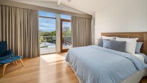 Un dormitorio con cama, una silla y un ventilador de techo.