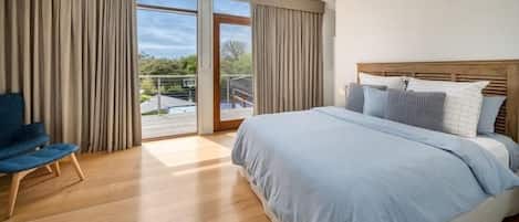 A bedroom with a bed, a chair, and a ceiling fan.