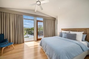 Un dormitorio con cama, una silla y un ventilador de techo.