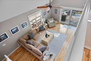 A modern living room with a sofa, coffee table, and ceiling fan.