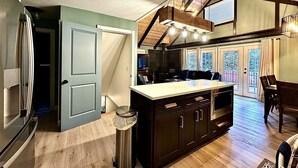 A spacious kitchen with a large island, wooden flooring, and a high ceiling with skylights. - 3BDR Home by Torch Lake Sandbar 11931 (Rapid City)