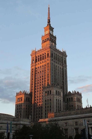 A large, historic building with a prominent clock tower, multiple floors, and a symmetrical facade.