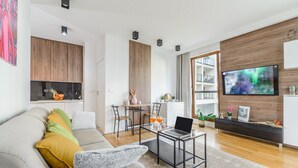 Un salon moderne avec un canapé, une table basse et un téléviseur à écran plat.