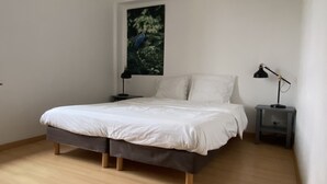 A bedroom with a bed, two bedside tables, a nightstand, and a painting on the wall. - Les Deux Ponts (Pierre-Perthuis)
