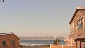 Un hogar de ladrillo con vista al océano y un edificio al fondo.