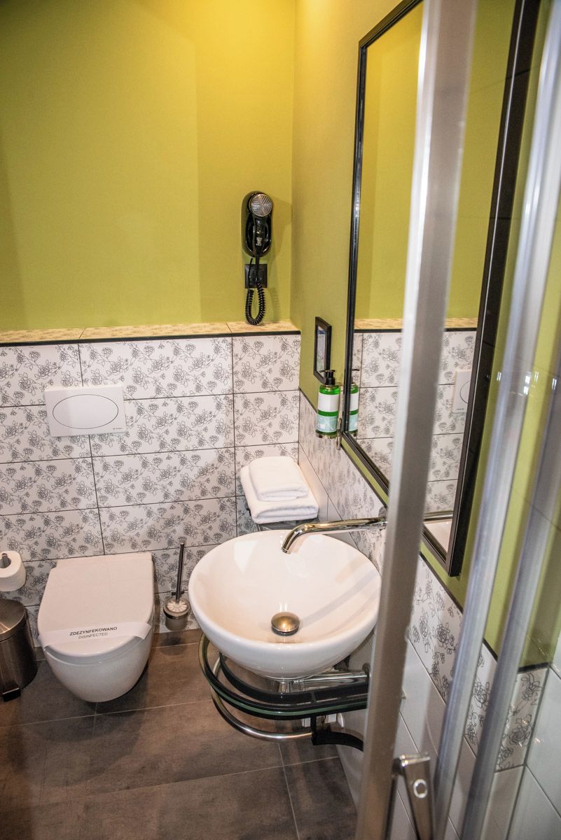 A bathroom with a toilet, sink, and a mirror.