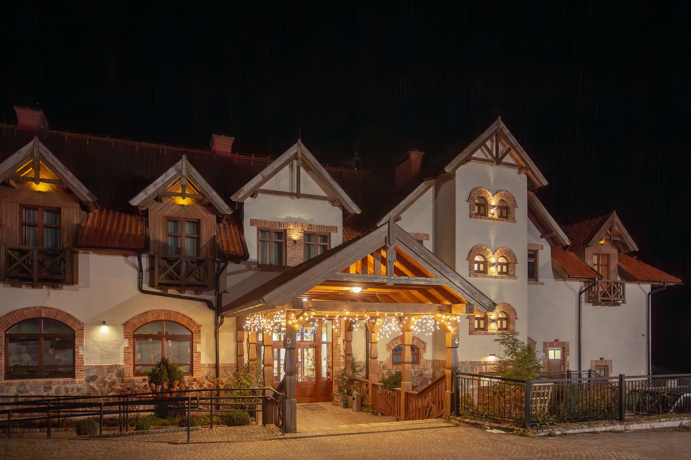 A traditional chalet-style building with a covered entrance, stone walls, and wooden balconies.