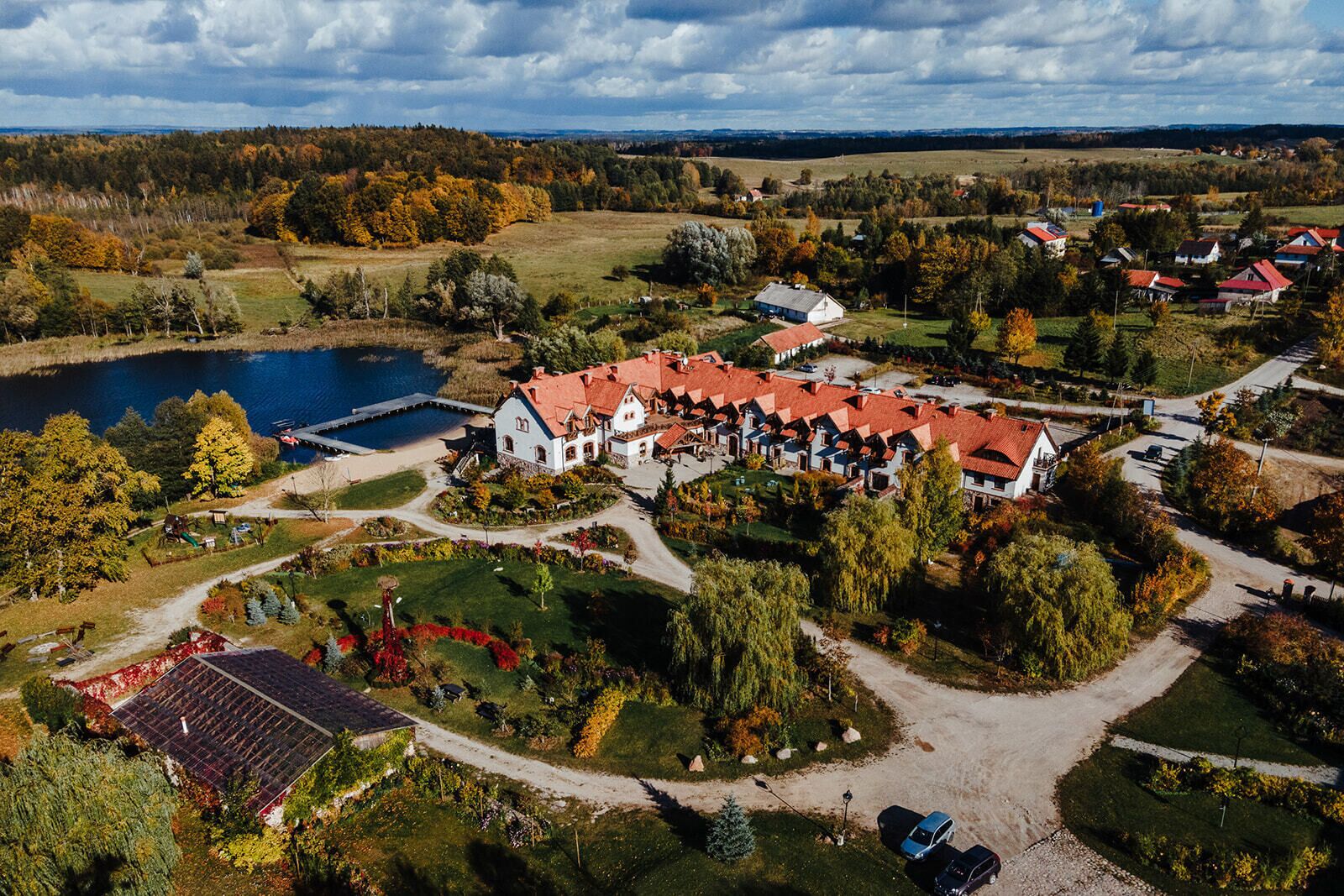 A large estate with multiple buildings, a lake, and a well-maintained garden.