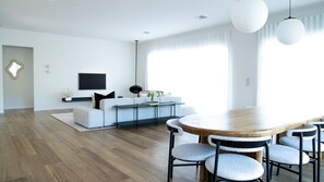 Una sala de estar moderna con un sofá, una mesa de centro y una mesa de comedor con sillas.
