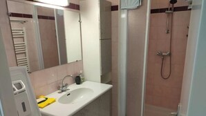A bathroom with a sink, mirror, shower, and a dryer. - St Cyprien: Calm and gentleness on the edge of the lagoon (Saint-Cyprien)
