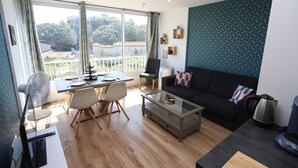 A modern living room with a dining area, large windows, and a view of greenery. - St Cyprien, a gem on the port, everything within easy reach (Saint-Cyprien)