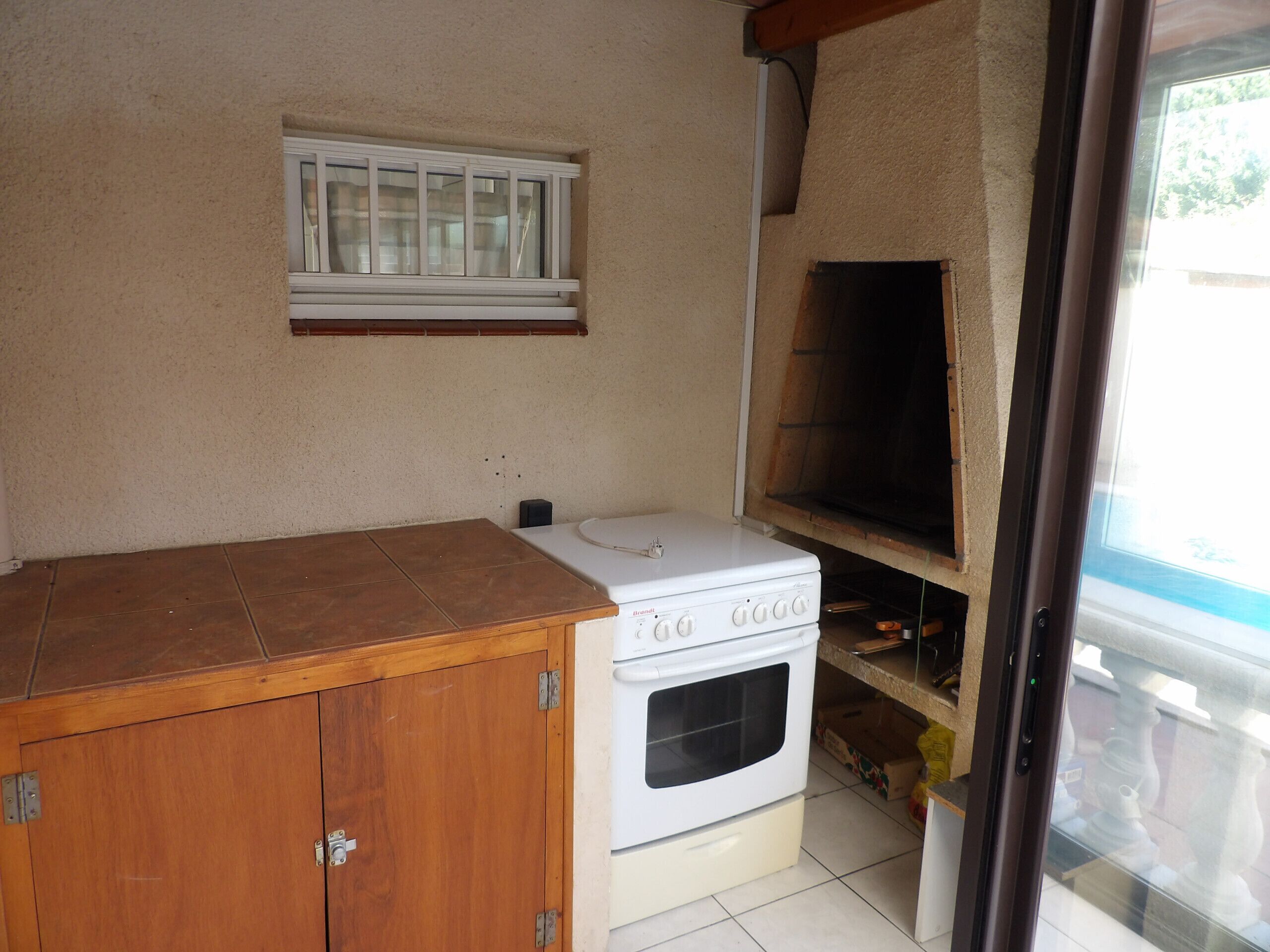 A kitchen with a stove, oven, and a window above the counter.