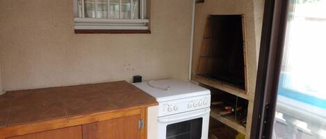 A kitchen with a stove, oven, and a window above the counter.